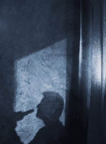 Silhouette of a man drinking from a beer bottle